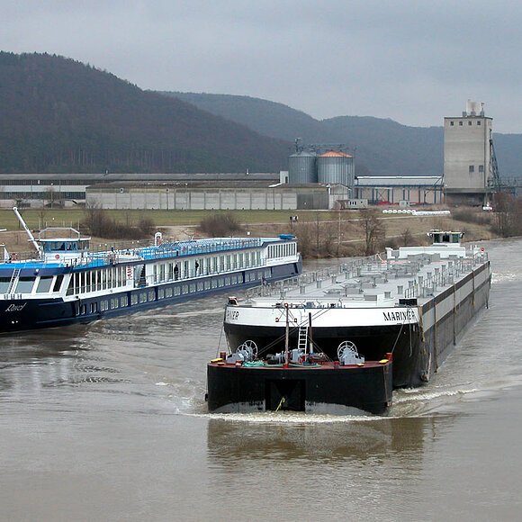 Zwei Güterschiffe auf dem Kanal mit Hafengebäude im Hintergrund