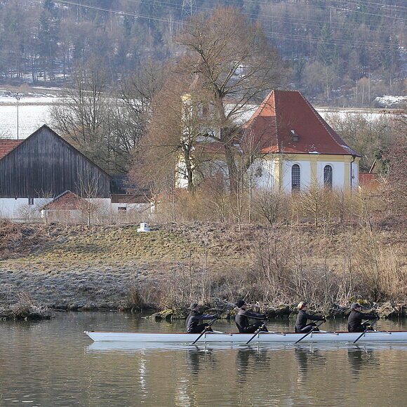 Rudern am Kanal Ein Ruderboot auf dem Kanal vor der Wallfahrtskirche Griesstetten