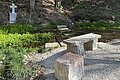 Wald im Hintergrund, Steinkreuz Wasser, Steine im Wasser und Steine als Abgrenzung