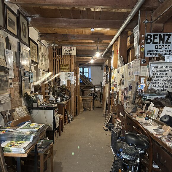 an den Bildrändern seitlich des Ganges in der Mitte sind viele Schilder und Bilder zu sehen.